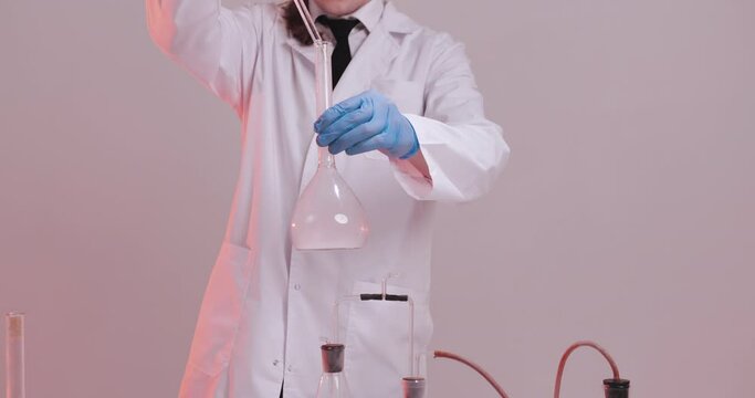 Scientist working in laboratory, processing of the laboratory sample in an Erlenmeyer flask, titration with reagent from a burette.