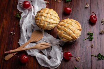 Mini coconut pie  with red cherry on wooden table.