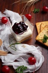Blueberry cheese pie with cherry and Biscuits on wooden table.