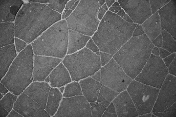 background close up of black cracked tar skin black with sand in cracked texture