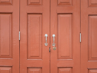 Fototapeta premium Old crimson red painted wooden door background. Vintage and retro style doors made of wood.