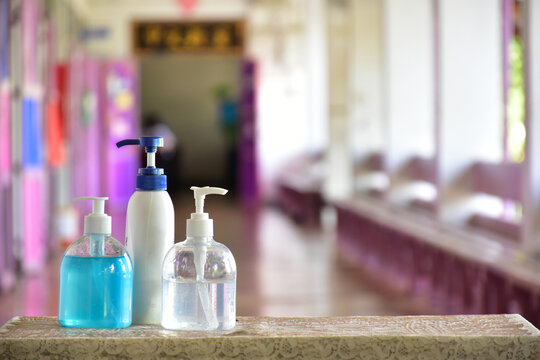 New normal, hand sanitizer, alcohol gel and hand soap on table in front of classroom. Concept for pretecting and preventing coronavirus or covid-19 and germs.