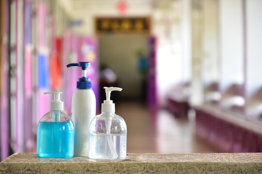 New normal, hand sanitizer, alcohol gel and hand soap on table in front of classroom. Concept for pretecting and preventing coronavirus or covid-19 and germs.