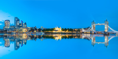 Naklejka premium Panorama of the Tower Bridge and Tower of London on Thames river at twilight blue hour - London England
