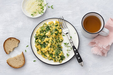 Scrumble eggs with kale and cheese on a light gray background, top view. delicious homemade breakfast