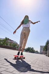 Student girl at pink skateboard. Local city traveller. Staycation lifestyle. Back view teenager....