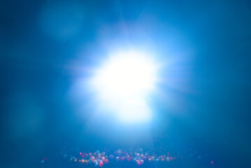 Fototapeta na wymiar Blue light flare special effect and beads on black background , concert lighting .