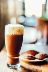 Iced cocoa drink  with whipped cream and Brownie cookies on wood table.