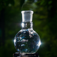 Glass flask with boiling water on a gas burner.