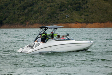 family ridding a white boat at lake calima