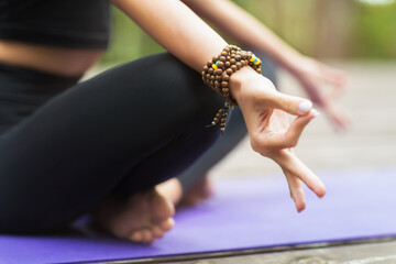 A girl practicing yoga sits in a lotus pose and shows a sign of Gyan mudra, a concept of meditation...