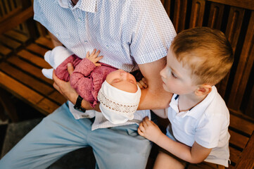 Young parent at the church with their baby wearing a christening gown. Parents and godparents stand...
