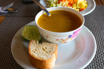 hot chicken soup with bread, lemon and salad