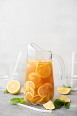 iced tea with lemon slices in a glass jug