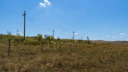 Summer steppe landscape. Landscape in kazakhstan. Kazakh steppe. Power line. Blue sky. Yellow grass. Panorama