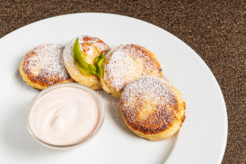 pancakes with sour cream on white plate
