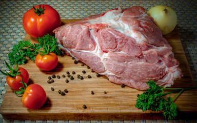 Fresh pork meat on a wooden surface near tomatoes parsley onion concept of cooking meat dishes restaurant food steak kebab