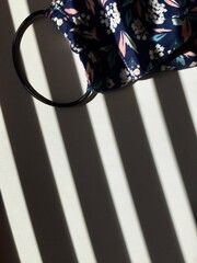textile face mask on a background of striped shadows