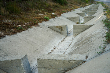 unusual rainfall along a mountain road with jumpers to reduce the speed of water flowing down the...