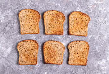 Crispy toasted bread for toast on gray background