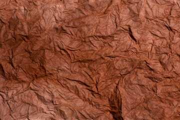 Background of raw crumpled paper. Brown recucled paper with big folds.