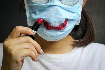 A Woman makes lipstick mark on her mask