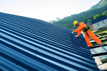 Construction worker install new roof at construction site,Electric drill used on new roofs with...