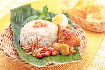 Nasi Lemak on a Leaf with Kerupuk or Crackers on Background
