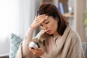 health, cold and people concept - sad sick young asian woman having headache with painkiller...