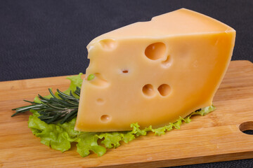 Maasdam cheese  in the board served salad leaves