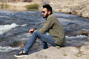 Handsome man sitting on the edge of the River