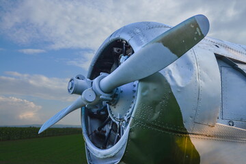 Airplane engine with propeller an old World War 2 plane in a field next to a sunflower field