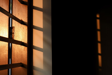Evening sunlight falls on the window and creates peculiar shades on the window sides and inside the room. 