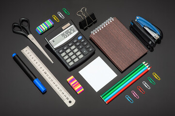 Composition with various school stationery and calculator on glass background
