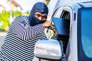 Transportation, crime and ownership concept -Young asian man thief stole a leather bag from a car...