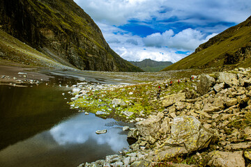 Mountain landscape with lake and mountain. The light coming between both hills makes water reflection, a small corridor from Parvati valley to Lahul and Spiti valley. Himachal Pradesh, India.