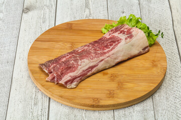 Raw beef bacon over wooden board
