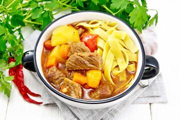 Lagman in bowl on white wooden board