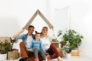 Family unpacking cardboard boxes at new home