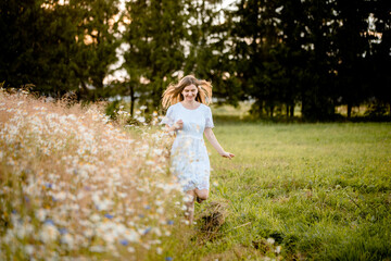 Glow Sun. Selective focus, lifestyle.Beauty Girl Outdoors enjoying nature. Beautiful Model girl in white dress running on the Field, Sun Light. . Free Happy Woman. Toned in warm colors. Autumn.