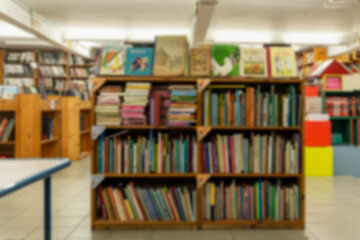 Wooden shelves with books in the store. Large selection of literature. Blurred.