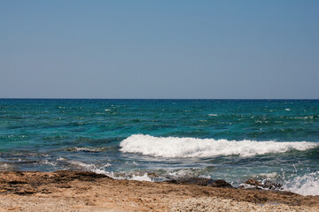 Background of blue sea. Rocky coast of the sea. Mediterranean sea in Cyprus. Nature background. Blue lagoon. Sea shore with summer Sunny day.