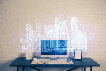 Desktop computer background in office and big town buildings hologram drawing. Double exposure. Smart city concept.