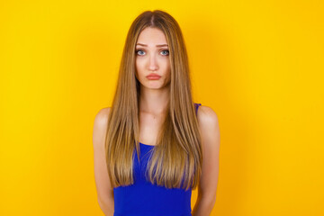 Beautiful face of sad woman crying desperate and depressed with tears on her eyes suffering pain and depression isolated on grey background in sadness facial expression and emotion concept.