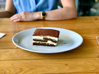 Tiramisu. Traditional italian dessert on white plate at Local Restaurant.