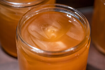 Golden yellow honey in glass jar on wooden board Closeup Copy space comp frame empty textspace