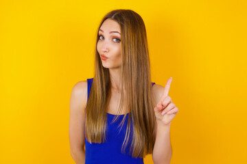 Woman gesturing a no sign. Closeup portrait unhappy, serious girl raising finger up saying: oh no you did not do that. Standing over yellow background. Negative emotions facial expressions, feelings.