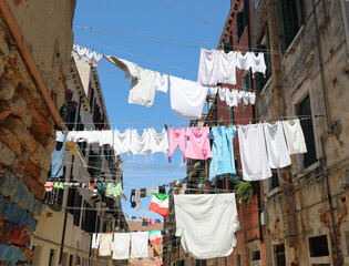 clean clothes hanging out to dry in the sun and an Italian flag