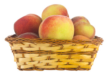 Juicy ripe, sweet peaches in a wicker basket isolated on a white background close-up.