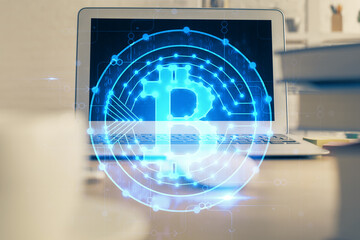 Multi exposure of blockchain theme hologram and table with computer background. Concept of bitcoin crypto currency.